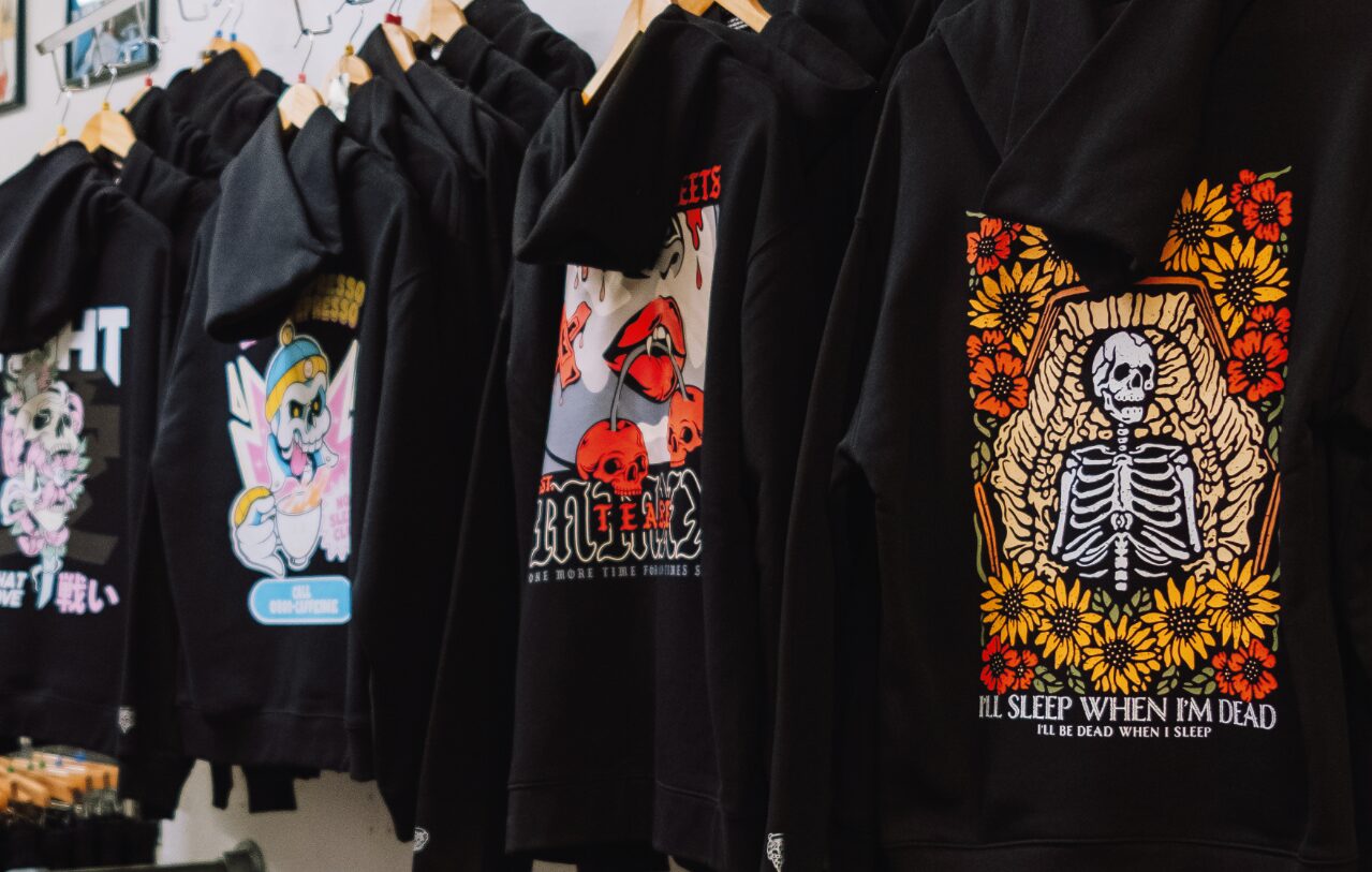 Black Modern Streets hoodies on a rail, each with a full-colour back print